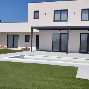 Kuća sa zelenom travom i bazenom