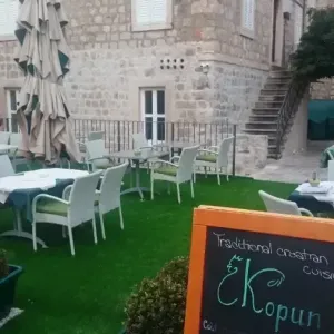 Terasa sa stolom i stolicama ispred kuće